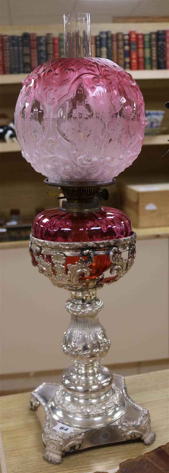 A silver plated and cranberry glass oil lamp 62cm